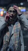A worried person is having a serious phone conversation in a busy city at night video