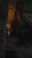 Adventurer on a journey is exploring a mysterious cave while holding a torchlight video