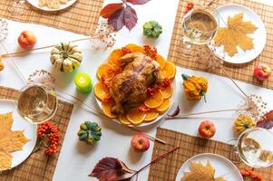 Festive thanksgiving dinner table is set with a roasted turkey as the centerpiece, top view photo