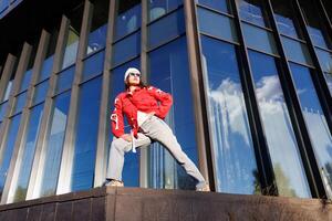 Young woman standing near building and enjoying moment. Freedom and joy concept photo