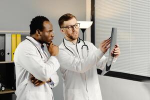 Two men in white lab coats analyzing xray photo