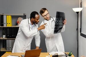Two men in white lab coats analyzing xray photo