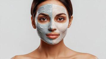 Portrait of Indian woman wearing a dual-tone clay face mask, highlighting skincare and beauty routine. photo