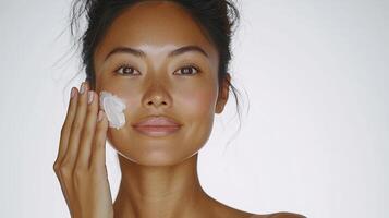 Moisturizing skincare routine with woman applying cream on her face photo