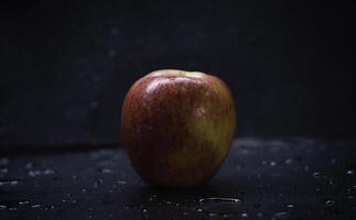 Red apple put wet background,show texture of peel and shape photo