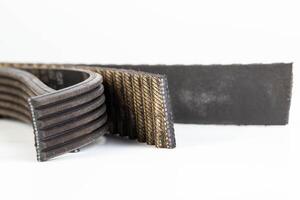 Torn timing belt and generator rivulet belt on a white background. Broken belts in the car, industry, close-up photo