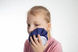 A seven-year-old girl applies a cold compress to a sore tooth. Relieving inflammation and pain in the tooth with cold, close-up. Local cryotherapy photo