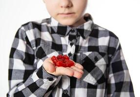 The girl holds red chewable vitamins in the form of bears in her hand. The concept of a multivitamin complex for the health and immunity of children during growth. Vitamin A and B complex, close-up photo