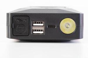 Power bank for starting a car engine with a flashlight. USB connectors, close-up photo