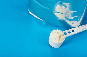 Shiny package with powdered baby milk food on a blue background. Baby formula. Copy space for text photo