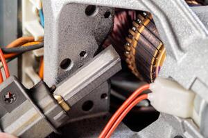 Replacing graphite electric motor brushes, close-up, industry. Copy space for text photo