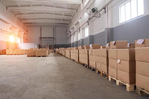 Warehouse of the customs terminal for the seizure of confiscated products. Large room with boxes and window with sunset, copy space for text photo