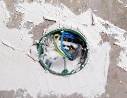 Socket box with wires built into the wall for a socket, close-up photo