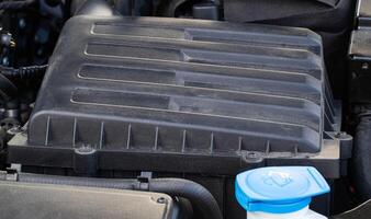 Car air filter housing for cleaning the air entering the engine, close-up photo