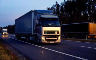 A beautiful truck with a trailer against the backdrop of an evening sunset before night. The concept of work and rest regime for truck drivers. Fine for breaching rules photo