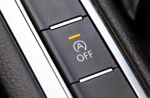 Button to turn off the start-stop system in a modern car, macro photo