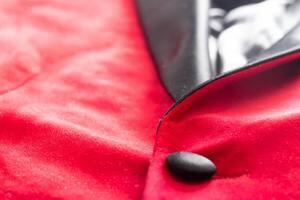 Red stylish jacket with buttons, background. Stylish clothes, macro, elegant photo