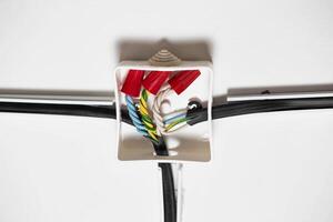 Connection of electrical wires in electrical boxes using red caps of connecting insulating clamps, close-up. Electrical installation photo