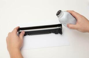 Refilling toner in a laser printer cartridge on a white background. Copy space for text photo