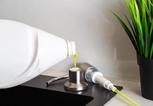 Dismantled detergent dispenser built into the sink. Adding soap to the dispenser. Copy space for text photo