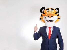 Man businessman in tiger mask on white background and showing class gesture. Copy space for text photo