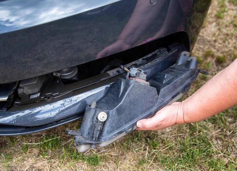 Disassembling and removing the fog lamp from a car to replace a burnt out light bulb. Close-up photo