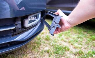 Disassembling and removing the fog lamp from a car to replace a burnt out light bulb. Close-up photo