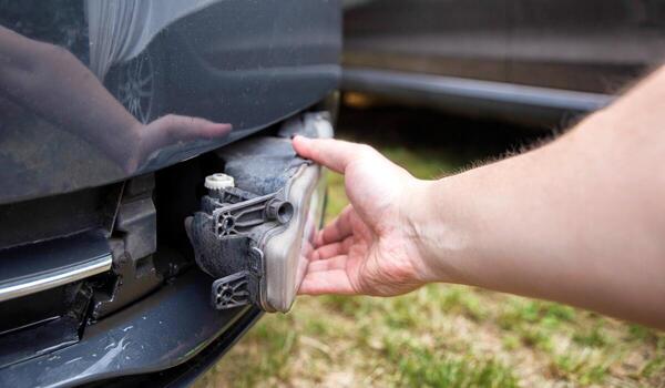Disassembling and removing the fog lamp from a car to replace a burnt out light bulb. Close-up photo