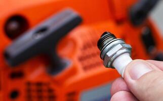 Dry spark plug in a chainsaw. Lean mixture of fuel. Malfunction in the ignition system. photo