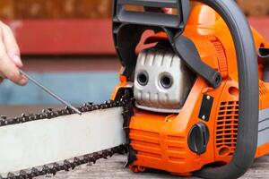 chainsaw chain sharpening with a special file. Dulling an old chain on a chainsaw bar. Industry photo