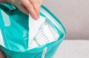Unpacking a whole package of baby diapers on a white background. Copy space for text photo