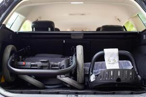 transporting a baby stroller in the trunk of a car when folded, close-up photo