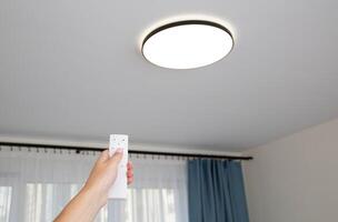 Modern LED ceiling chandelier with on off control panel. Adjusting the brightness of the lighting in the room, technologies. Sleep timer photo