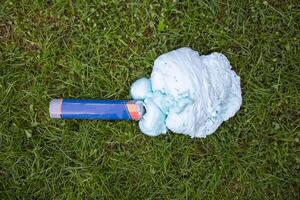 An exploded cylinder with construction foam on the grass. Balloon defect, close-up photo