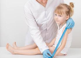 The doctor measures the length of the arm of a child of a girl 4 years old. Child growth measurement and anthropometric data concept. Copy space for text photo