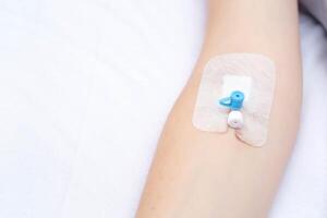 Intravenous catheter on the girl's arm for convenient injection of drugs into a vein, copy space for texr photo