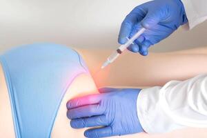 The doctor makes the patient a medication blockade in the area of the sciatic nerve buttocks. Concept of a complex of medicinal products in a drug blockade to eliminate pain photo