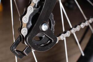 Gearshift on mountain bike MTB, chain moves on rings. Changes speeds. Shift gears on bicycle crank. Work of chain drive chainset. Front derailleur. Macro closeup low angle shot. Wheel spins and turns photo