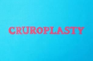 The word cruroplasty in red letters on a blue background. The concept of the procedure in plastic surgery for changing the correction of the shape of the leg with the help of implants photo