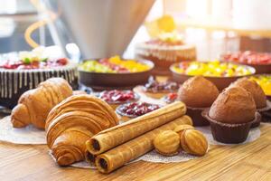 Production for the production of desserts. Croissants and cake in tartlets with cakes, nuts with condensed milk lie on a wooden table, torte photo