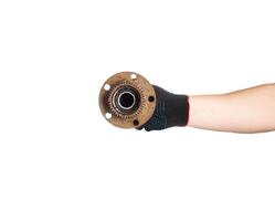 Rusty old hub with a bearing in the hand of a car mechanic on a white background, isolate. Repair and replacement of the hub, close-up photo