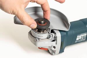 Installing the support flange on the angle grinder before starting work. Close-up photo
