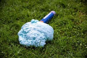 An exploded cylinder with construction foam on the grass. Balloon defect, close-up photo