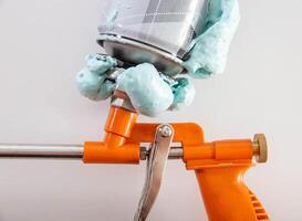 Construction foam gun with a defective cylinder. Foam bottle defect, close-up photo