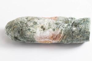 Green moldy bread on a white background, isolate. Loaf with mold, macro photo