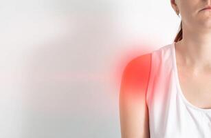 Girl on a white background who has pain in the shoulder. Copy space for text photo