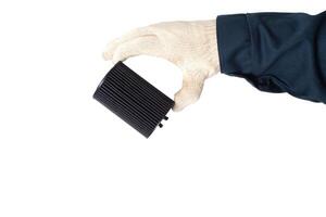 An auto mechanic holds in his hand an old dirty oil filter on a white background, isolate. Car oil and filter replacement concept, replacement schedule photo