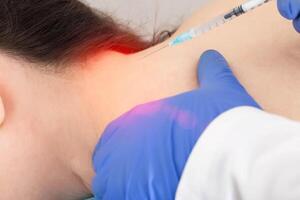The doctor makes the procedure of local injection therapy of blockade in the occipital region of the head. Kotsnept treatment of diseases of the occipital nerve and pain in the head photo
