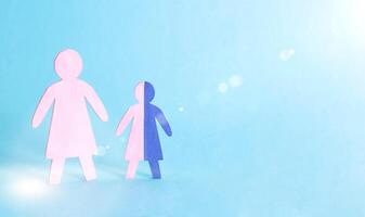 Figures of mother and baby on a blue background. Single mother concept raising a child without a father, guardianship, copy space photo