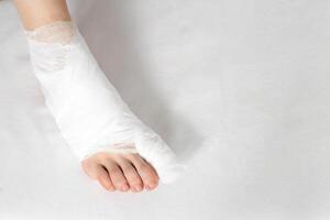 Bandaged big toe with foot on white background. Concept of fracture of the foot and thumb, close-up, copy space photo